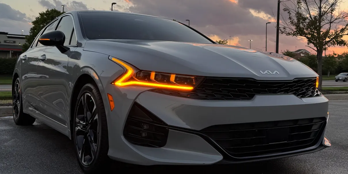 Grey Kia K5 GT-Line with glowing headlights after exterior detail